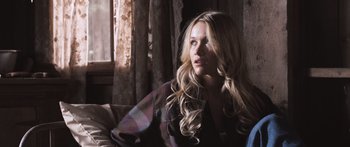 Movie still from “Tucker and Dale vs Evil” (2010), directed by Eli Craig – A woman sitting on a couch in front of a window; Close Up shot, Over the shoulder angle
