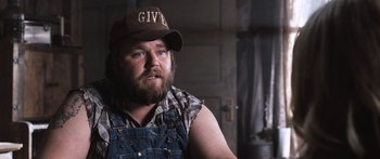 Movie still from “Tucker and Dale vs Evil” (2010), directed by Eli Craig – A man with a beard wearing a hat and overalls; Close Up shot, Over the shoulder angle