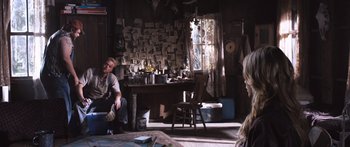 Movie still from “Tucker and Dale vs Evil” (2010), directed by Eli Craig – A man sitting on a chair in front of a window; Wide shot, Over the shoulder angle