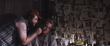 Movie still from “Tucker and Dale vs Evil” (2010), directed by Eli Craig – A man is putting makeup on another man's face; Medium shot, Over the shoulder angle