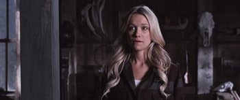 Movie still from “Tucker and Dale vs Evil” (2010), directed by Eli Craig – A woman with long blonde hair standing in a dark room; Close Up shot, Over the shoulder angle