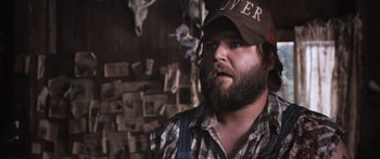 Movie still from “Tucker and Dale vs Evil” (2010), directed by Eli Craig – A man with a beard wearing a hat and overalls; Close Up shot, Over the shoulder angle