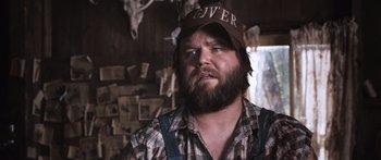 Movie still from “Tucker and Dale vs Evil” (2010), directed by Eli Craig – A man with a beard wearing a hat and overalls; Close Up shot, Over the shoulder angle