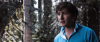 Movie still from “Tucker and Dale vs Evil” (2010), directed by Eli Craig – A young man standing in front of a forest; Close Up shot, Over the shoulder angle