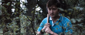 Movie still from “Tucker and Dale vs Evil” (2010), directed by Eli Craig – A man holding a baseball bat in the woods; Close Up shot, Over the shoulder angle