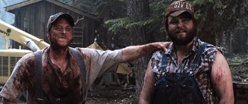 Movie still from “Tucker and Dale vs Evil” (2010), directed by Eli Craig – A man is pointing at another man with blood on his arm; Medium shot, Over the shoulder angle