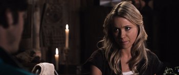 Movie still from “Tucker and Dale vs Evil” (2010), directed by Eli Craig – A woman sitting in front of candles in a dark room; Close Up shot, Over the shoulder angle