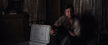 Movie still from “Tucker and Dale vs Evil” (2010), directed by Eli Craig – A man sitting in front of an open stove holding a beer; Medium shot, Low angle