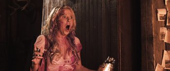 Movie still from “Tucker and Dale vs Evil” (2010), directed by Eli Craig – A woman is holding a jar with blood on her face; Medium shot, Low angle