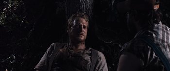 Movie still from “Tucker and Dale vs Evil” (2010), directed by Eli Craig – A person in a forest near a tree; Close Up shot, Over the shoulder angle