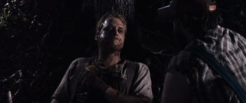 Movie still from “Tucker and Dale vs Evil” (2010), directed by Eli Craig – A man with a beard is standing next to a tree; Medium shot, Over the shoulder angle