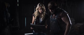 Movie still from “Tucker and Dale vs Evil” (2010), directed by Eli Craig – A man and a woman are looking at a newspaper; Medium shot, Over the shoulder angle