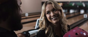 Movie still from “Tucker and Dale vs Evil” (2010), directed by Eli Craig – A beautiful blond haired woman smiling for the camera; Close Up shot, Over the shoulder angle