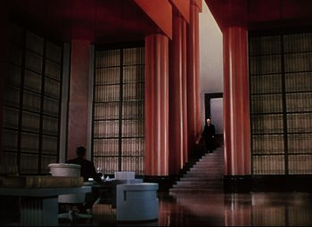 Movie still from “Heaven Can Wait” (1943), directed by Ernst Lubitsch – A man sitting at a table in front of a staircase; Extreme Wide shot, Low angle