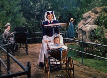 Movie still from “Heaven Can Wait” (1943), directed by Ernst Lubitsch – A woman and a baby in a carriage in a park; Wide shot, High angle