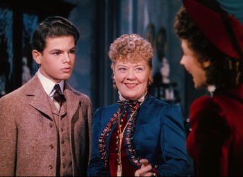 Movie still from “Heaven Can Wait” (1943), directed by Ernst Lubitsch – A woman and two men standing next to each other in a room; Medium shot, Over the shoulder angle