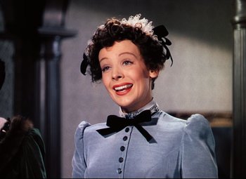 Movie still from “Heaven Can Wait” (1943), directed by Ernst Lubitsch – A woman in a blue dress with a black bow tie; Close Up shot, Over the shoulder angle