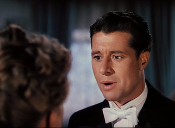 Movie still from “Heaven Can Wait” (1943), directed by Ernst Lubitsch – A man in a tuxedo talking to a woman in a suit; Close Up shot, Over the shoulder angle