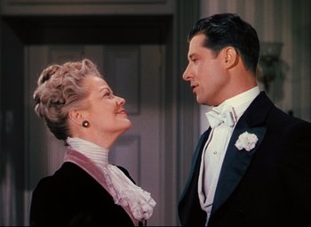 Movie still from “Heaven Can Wait” (1943), directed by Ernst Lubitsch – An older woman standing next to a man in a tuxedo; Medium shot, Low angle