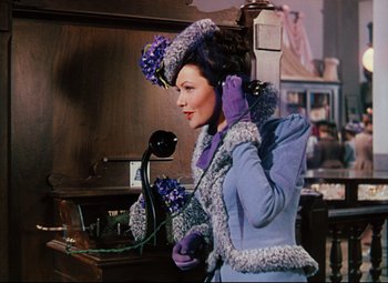 Movie still from “Heaven Can Wait” (1943), directed by Ernst Lubitsch – A woman in a purple outfit holding a phone to her ear; Medium shot, Low angle
