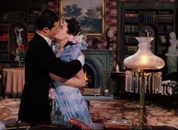 Movie still from “Heaven Can Wait” (1943), directed by Ernst Lubitsch – A man and a woman kissing in front of a fireplace; Medium shot, High angle