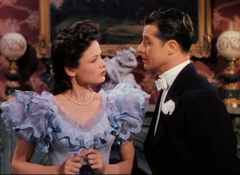 Movie still from “Heaven Can Wait” (1943), directed by Ernst Lubitsch – A man and a woman standing next to each other; Medium shot, High angle