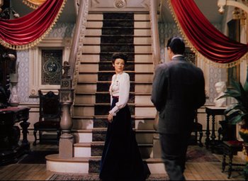 Movie still from “Heaven Can Wait” (1943), directed by Ernst Lubitsch – A man and a woman standing in front of a staircase; Wide shot, Low angle