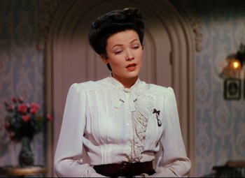 Movie still from “Heaven Can Wait” (1943), directed by Ernst Lubitsch – A woman wearing a white dress and a black hat; Close Up shot, Over the shoulder angle