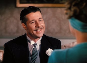 Movie still from “Heaven Can Wait” (1943), directed by Ernst Lubitsch – A man wearing a suit and tie sitting in front of a woman; Close Up shot, Over the shoulder angle