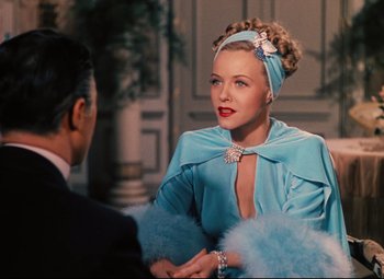 Movie still from “Heaven Can Wait” (1943), directed by Ernst Lubitsch – A woman in a blue dress talking to a man in a black suit; Medium shot, Over the shoulder angle