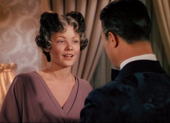 Movie still from “Heaven Can Wait” (1943), directed by Ernst Lubitsch – A woman in a purple dress and a man in a suit; Close Up shot, Over the shoulder angle