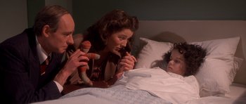 Movie still from “Heavenly Creatures” (1994), directed by Peter Jackson – A man and a woman laying in a bed with stuffed animals; Medium shot, High angle