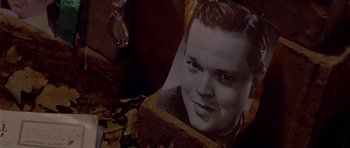 Movie still from “Heavenly Creatures” (1994), directed by Peter Jackson – An old photo of a young man is sitting on the ground; Extreme Close Up shot, High angle