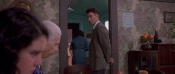 Movie still from “Heavenly Creatures” (1994), directed by Peter Jackson – A man in a suit standing in front of a mirror; Medium shot, Over the shoulder angle
