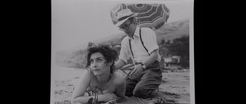 Movie still from “Heavenly Creatures” (1994), directed by Peter Jackson – An old photo of a man and a woman on the beach; Medium shot, High angle