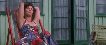 Movie still from “Heavenly Creatures” (1994), directed by Peter Jackson – A woman sitting on the ground in front of a building; Medium shot, Low angle