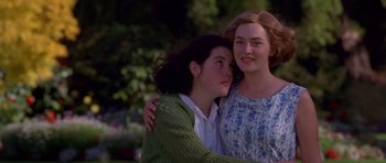Movie still from “Heavenly Creatures” (1994), directed by Peter Jackson – Two young women embracing each other in a park; Medium shot, Low angle