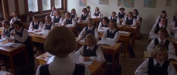Movie still from “Heavenly Creatures” (1994), directed by Peter Jackson – A group of people sitting at desks in a classroom; Wide shot, High angle
