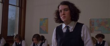 Movie still from “Heavenly Creatures” (1994), directed by Peter Jackson – A girl in a school uniform is standing in front of another girl; Close Up shot, Low angle