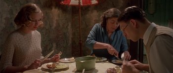 Movie still from “Heavenly Creatures” (1994), directed by Peter Jackson – A group of people sitting around a table eating; Medium shot, High angle