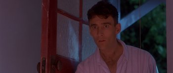 Movie still from “Heavenly Creatures” (1994), directed by Peter Jackson – A person wearing a white shirt near a door; Close Up shot, Low angle