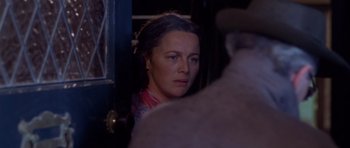 Movie still from “Heavenly Creatures” (1994), directed by Peter Jackson – A woman is looking at the camera in the dark; Close Up shot, Over the shoulder angle