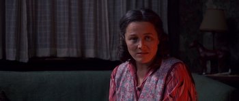 Movie still from “Heavenly Creatures” (1994), directed by Peter Jackson – A woman sitting on top of a couch in a living room; Close Up shot, Over the shoulder angle