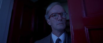 Movie still from “Heavenly Creatures” (1994), directed by Peter Jackson – An older man wearing a suit and glasses; Close Up shot, Low angle