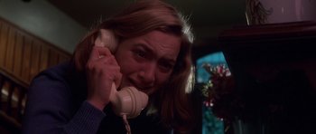 Movie still from “Heavenly Creatures” (1994), directed by Peter Jackson – A woman talking on a phone while sitting in a room; Close Up shot, High angle