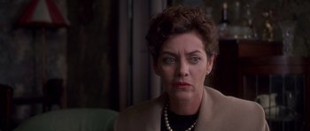 Movie still from “Heavenly Creatures” (1994), directed by Peter Jackson – An older woman wearing a pearl necklace stares at the camera; Close Up shot, Over the shoulder angle