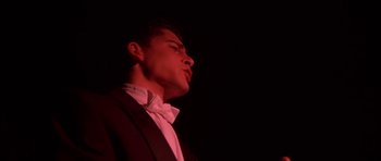 Movie still from “Heavenly Creatures” (1994), directed by Peter Jackson – A man in a suit and white dress shirt is looking up; Close Up shot, Low angle