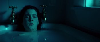 Movie still from “Heavenly Creatures” (1994), directed by Peter Jackson – A woman is in a bath tub in the dark; Close Up shot, Overhead angle