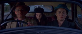 Movie still from “Heavenly Creatures” (1994), directed by Peter Jackson – A group of people sitting in the back of a car; Medium shot, High angle