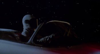 Movie still from “Heavy Metal” (1981), directed by Gerald Potterton – A person in a space suit sitting in a car; Medium shot, Low angle